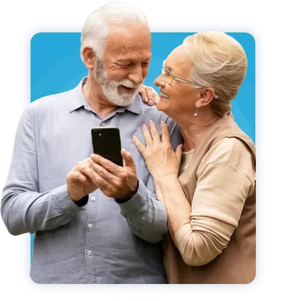 An image of a joyful elderly couple, peacefully smiling while holding a cellphone.